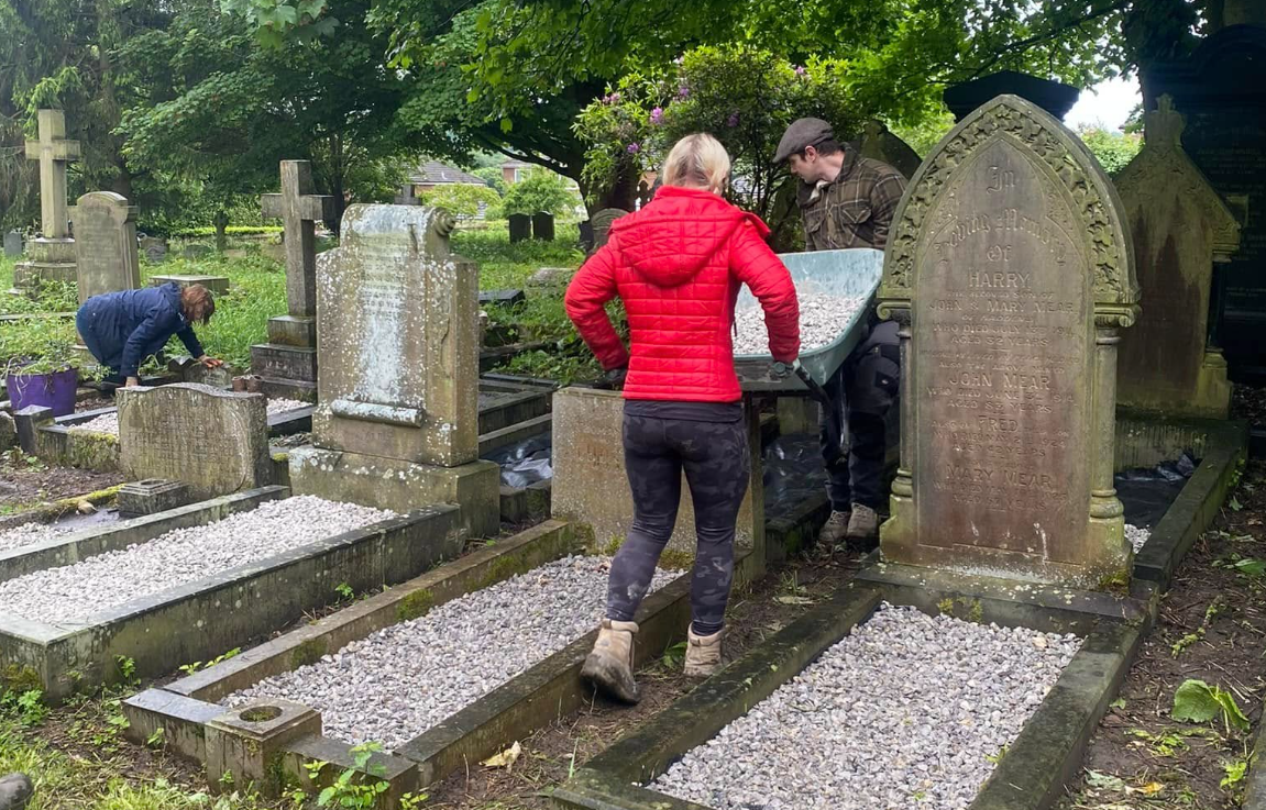 Volunteers spreading gravel and caring for individual graves.